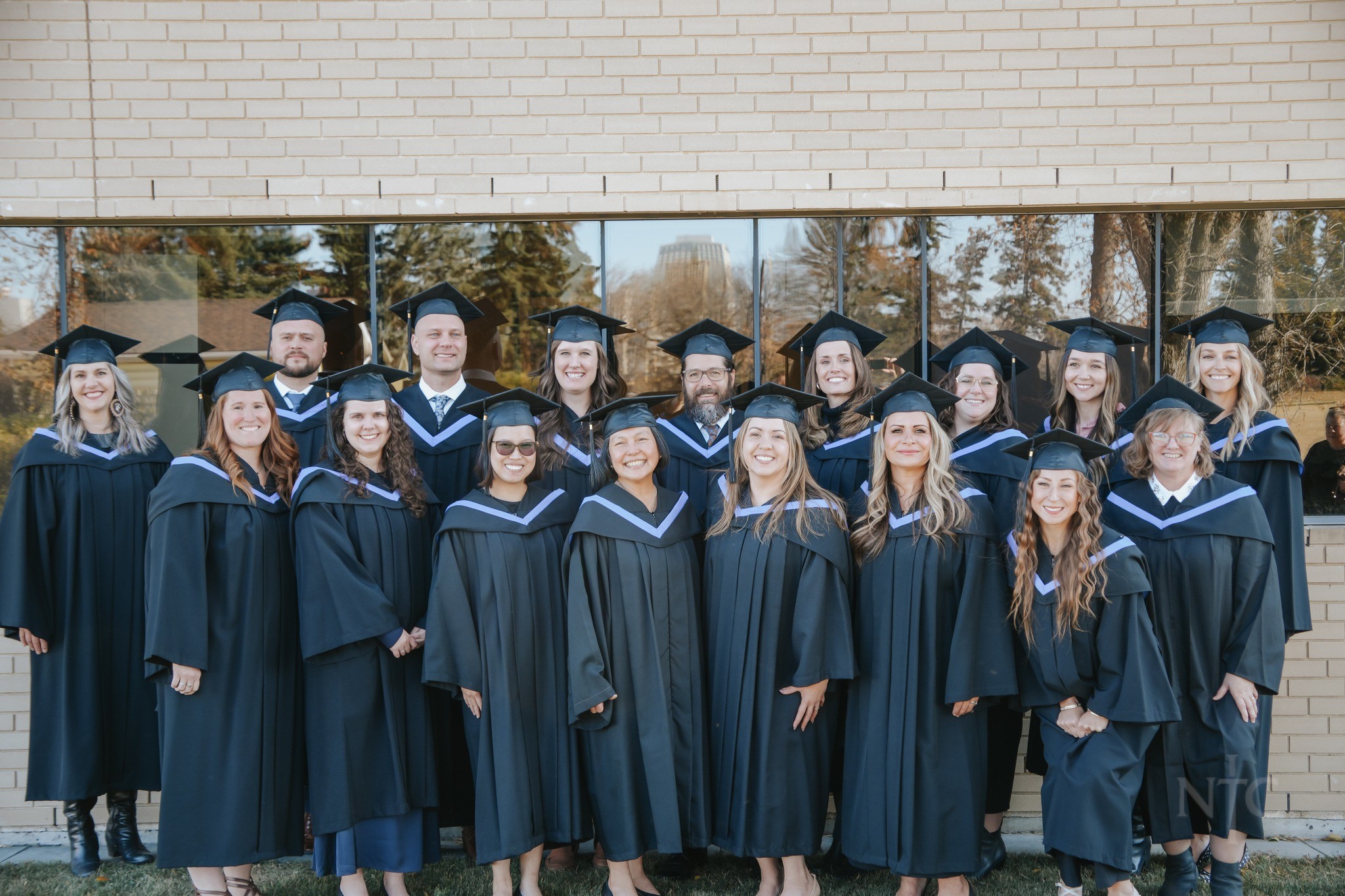 Group photo of graduates in cap and gown at Newman College