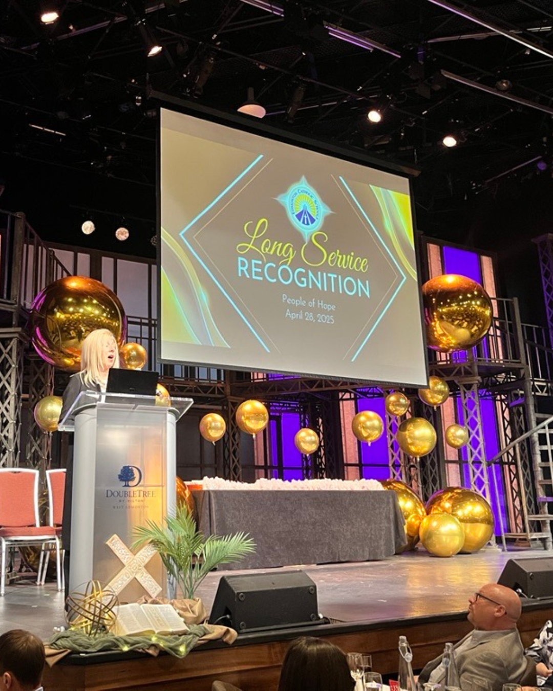 Trustee Palazzo at a podium on a stage for the Long Service Awards