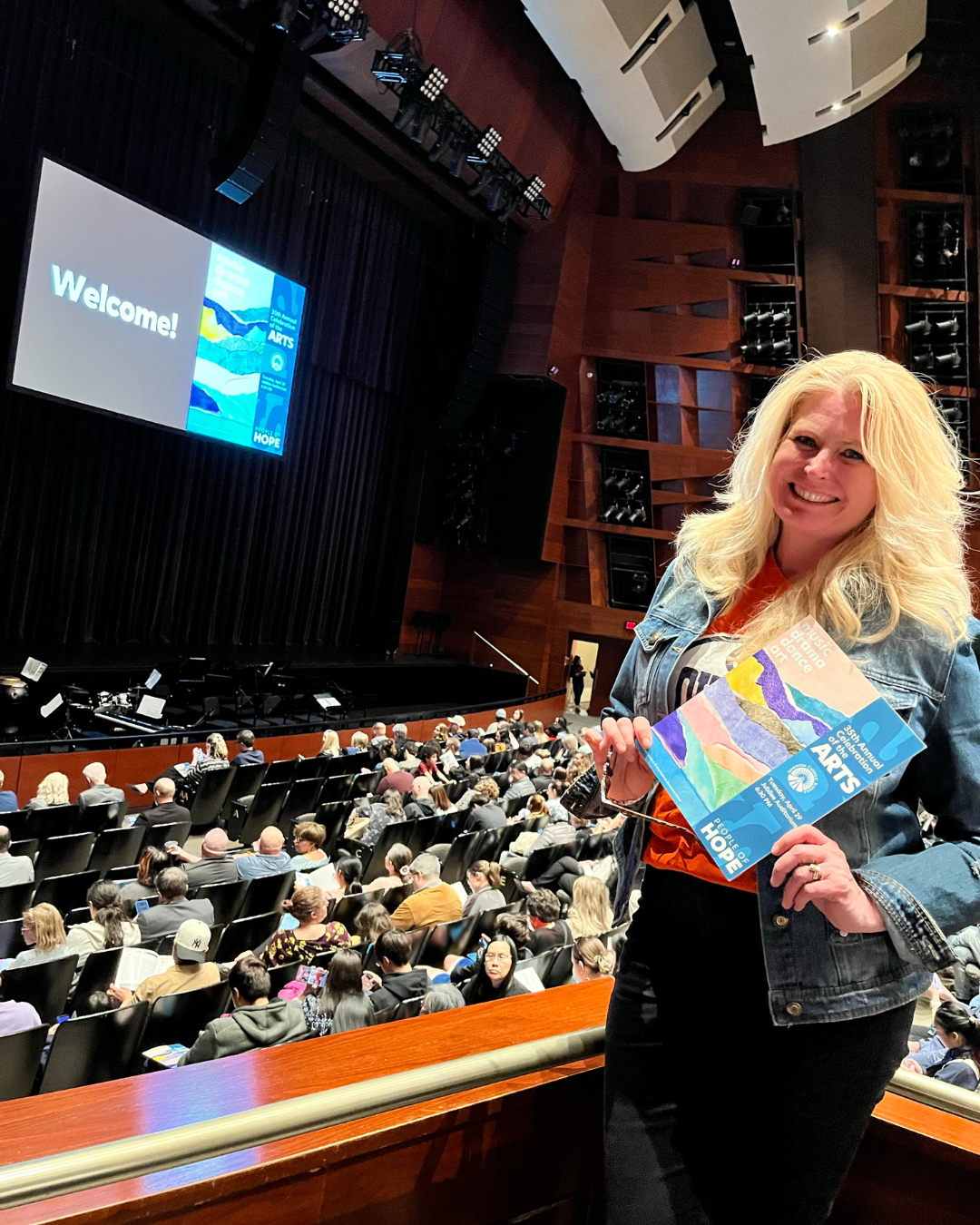 Trustee Laura Thibert posing with program at the Celebration of the Arts