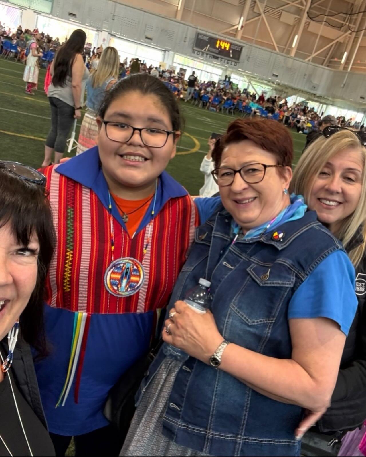 Trustees with a child at the powwow
