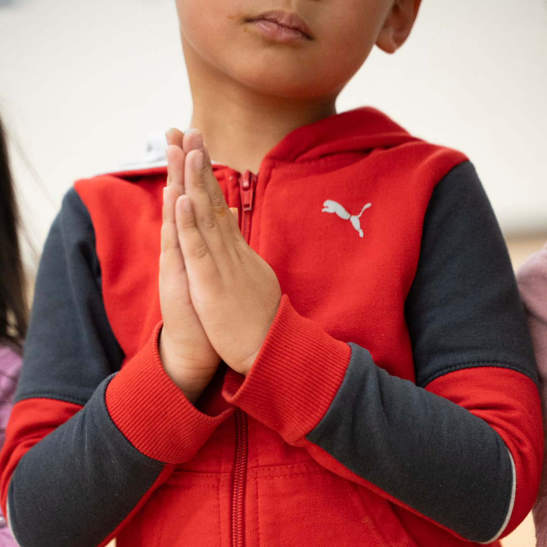Young student with hands clasped in prayer