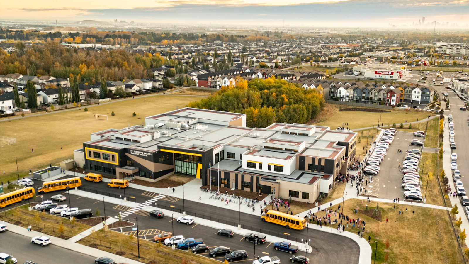 Aerial view of St. Josephine Bakhita Catholic School with yellow school buses parked out front